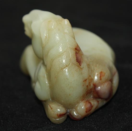 A Chinese celadon and brown jade figure of a recumbent horse, 20th century, 9.5cm